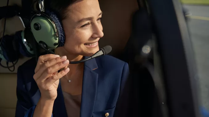 Pleased woman in noise-canceling headphones sitting in chopper