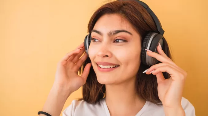 Young woman listening music with headphones.