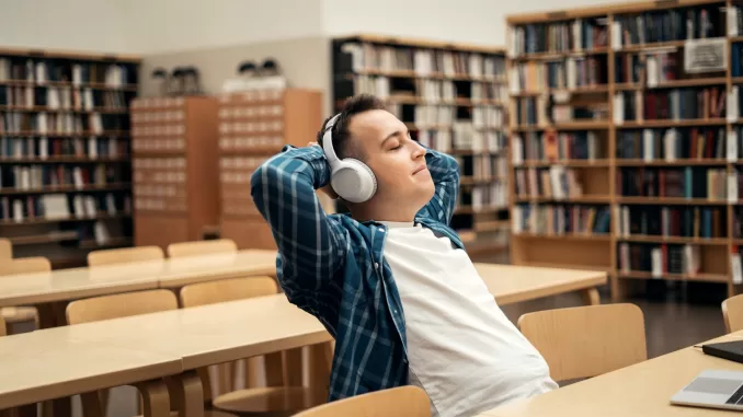a man listens to music and an audiobook with headphones gets pleasure