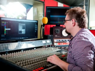 Sound producer working at recording studio using soundboard and monitors