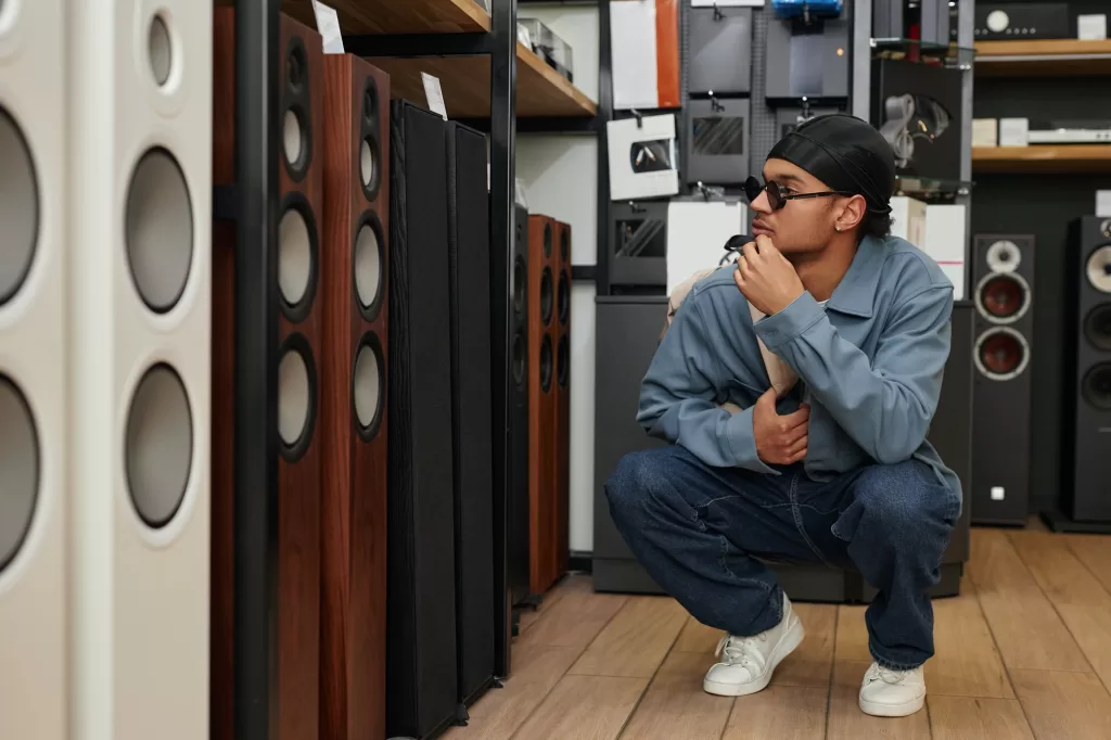 Young black man choosing professional speakers in music store