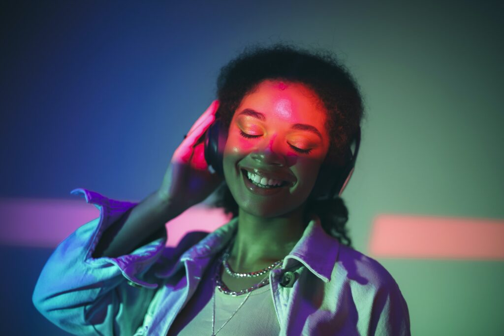 Young happy african american woman in headphones listening to music, enjoying high quality sound