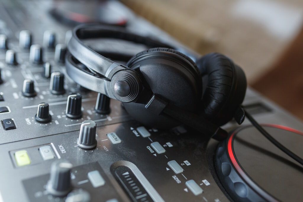 Audio Mixer with headphones. Elements and details of artists' working tools - DJ console with knobs and black headphones. Soft focus.